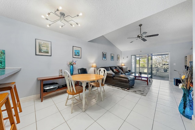 tiled dining area featuring a textured ceiling, ceiling fan with notable chandelier, and vaulted ceiling