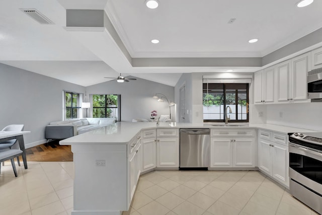 kitchen featuring lofted ceiling, sink, ceiling fan, appliances with stainless steel finishes, and kitchen peninsula