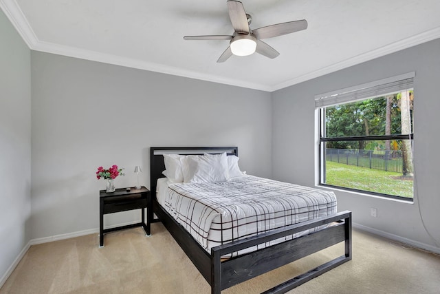 carpeted bedroom with multiple windows, ceiling fan, and crown molding