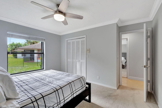 bedroom with ceiling fan, a closet, light carpet, and ornamental molding