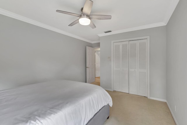 carpeted bedroom featuring ceiling fan, crown molding, and a closet