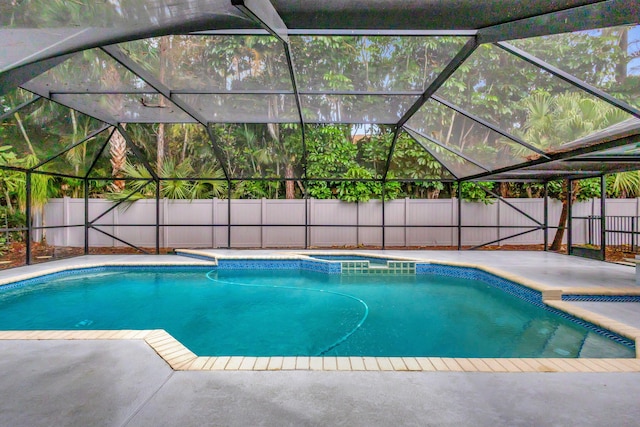 view of pool with glass enclosure and a patio