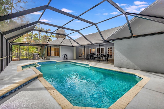 view of pool with a lanai, ceiling fan, a patio area, and an in ground hot tub