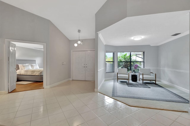 foyer entrance featuring crown molding, light tile patterned floors, and vaulted ceiling