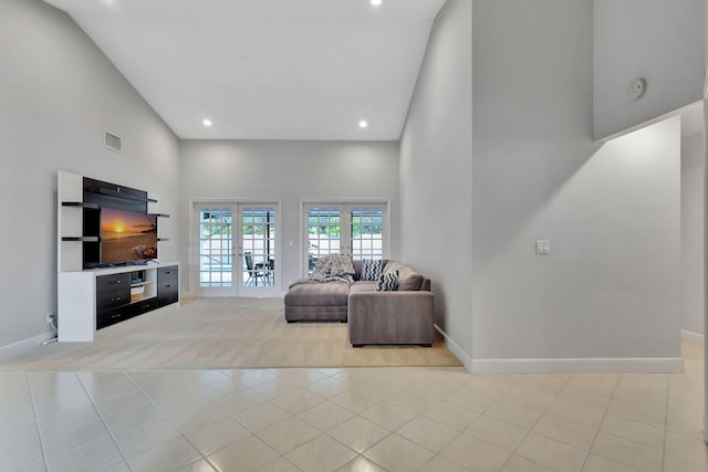 living room featuring light tile patterned floors, high vaulted ceiling, and french doors