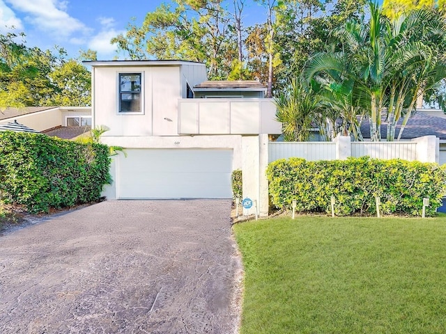 view of front of house with driveway, stucco siding, an attached garage, and a front yard