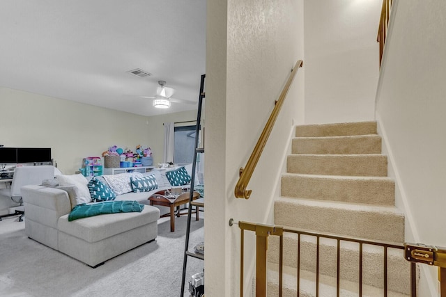 interior space with carpet floors, visible vents, and ceiling fan