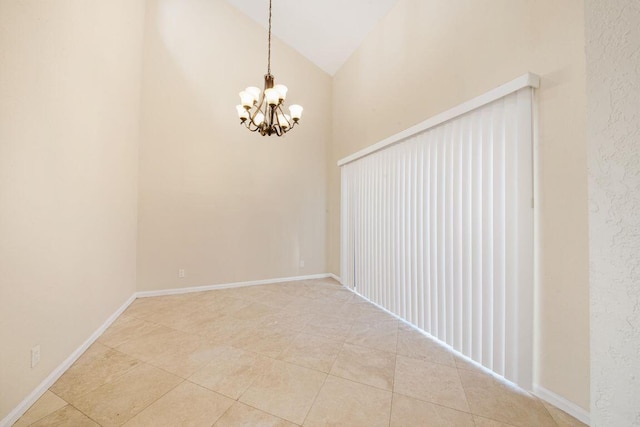 empty room with tile patterned floors, lofted ceiling, and an inviting chandelier