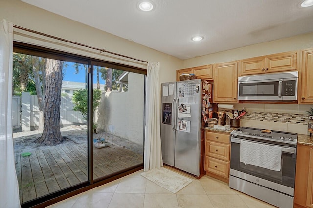 kitchen with light tile patterned floors, light stone countertops, light brown cabinetry, tasteful backsplash, and stainless steel appliances