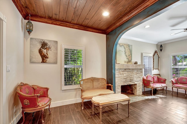 living area featuring a fireplace, dark hardwood / wood-style flooring, ceiling fan, and wood ceiling