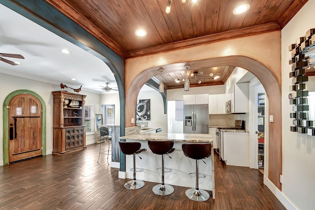 kitchen featuring white cabinets, stainless steel appliances, dark hardwood / wood-style floors, and wood ceiling