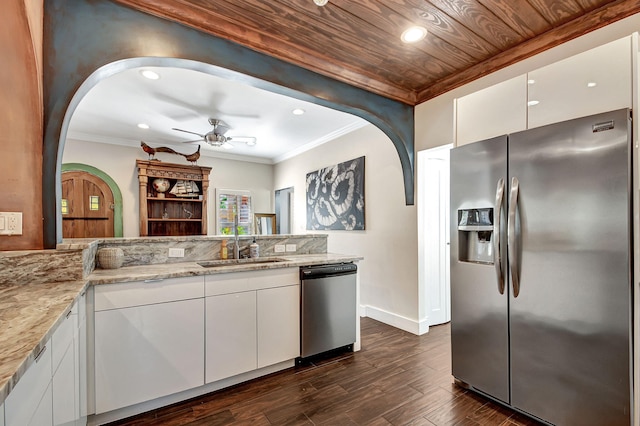 kitchen featuring appliances with stainless steel finishes, light stone counters, sink, dark hardwood / wood-style floors, and white cabinetry