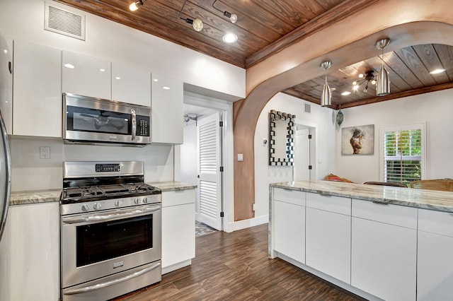 kitchen with dark wood-type flooring, appliances with stainless steel finishes, white cabinetry, light stone counters, and wood ceiling