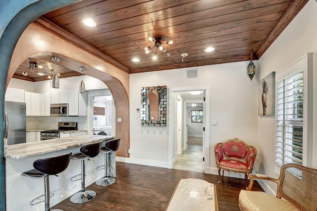 kitchen featuring wood ceiling, stainless steel appliances, dark wood-type flooring, white cabinetry, and hanging light fixtures