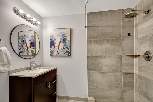 bathroom featuring tiled shower and vanity