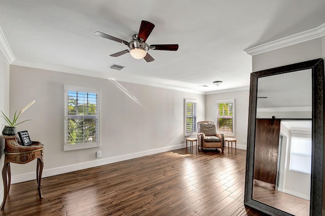 living area featuring a barn door, a healthy amount of sunlight, and dark hardwood / wood-style floors