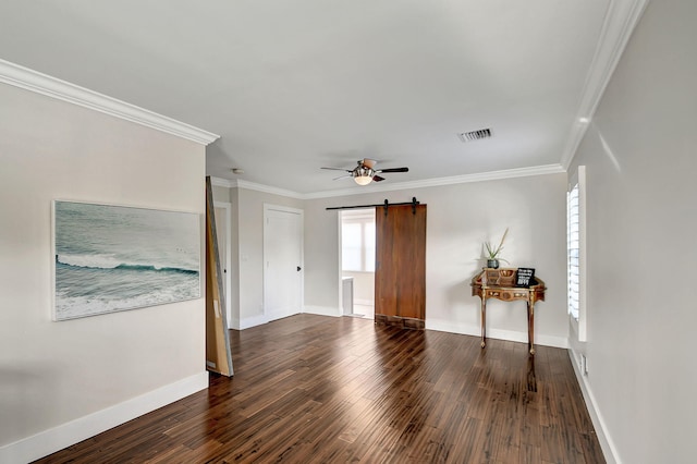 unfurnished room with a barn door, dark hardwood / wood-style floors, ceiling fan, and ornamental molding