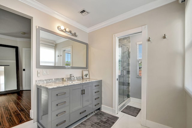 bathroom with hardwood / wood-style flooring, vanity, ornamental molding, and walk in shower