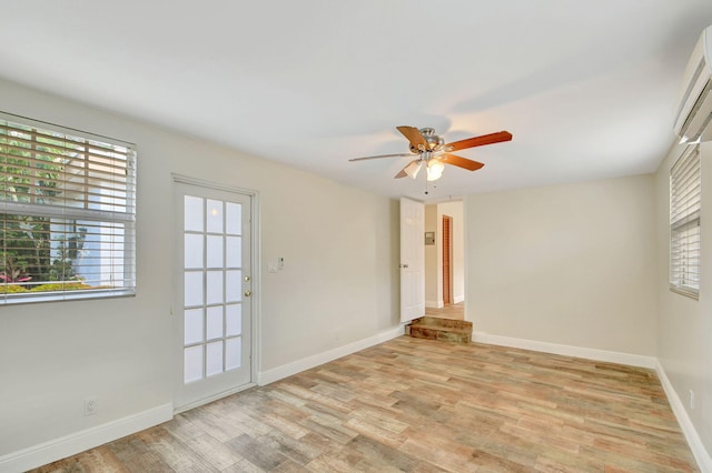 spare room featuring ceiling fan, light hardwood / wood-style floors, and a wealth of natural light