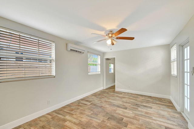 unfurnished room featuring light hardwood / wood-style flooring, a wall mounted AC, and ceiling fan