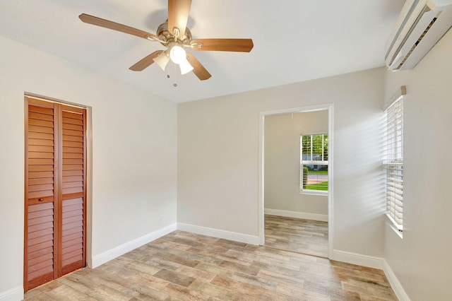 spare room featuring ceiling fan, light hardwood / wood-style floors, and a wall mounted AC