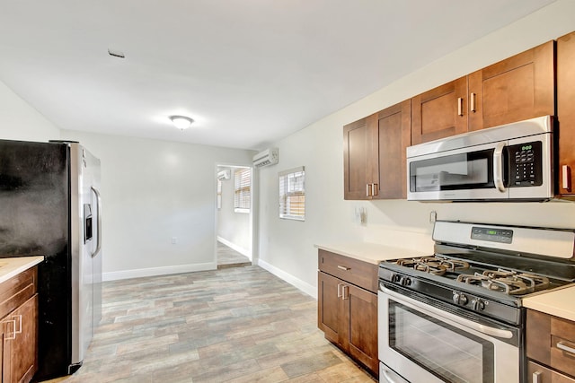 kitchen featuring light wood-type flooring, stainless steel appliances, and a wall mounted AC