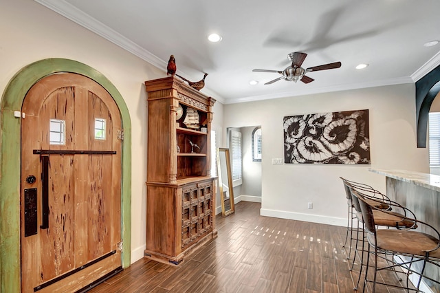 interior space with a healthy amount of sunlight, dark hardwood / wood-style floors, and ornamental molding