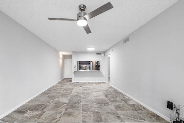 unfurnished living room featuring ceiling fan and a textured ceiling