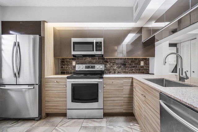 kitchen featuring a textured ceiling, decorative backsplash, sink, and stainless steel appliances