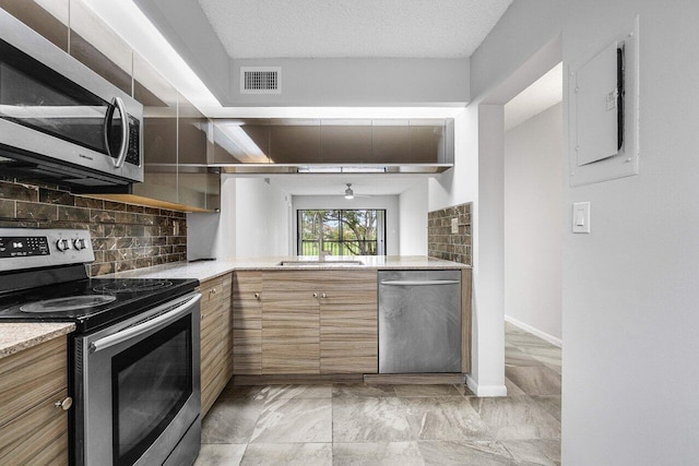 kitchen featuring electric panel, decorative backsplash, a textured ceiling, and appliances with stainless steel finishes