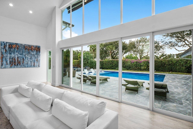 living room featuring plenty of natural light, wood-type flooring, and a high ceiling