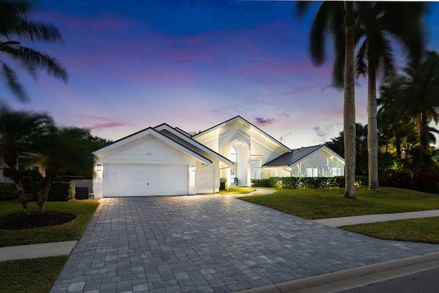 ranch-style home with a yard and a garage