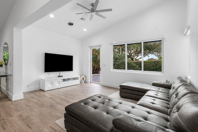 living room featuring ceiling fan, light hardwood / wood-style floors, and high vaulted ceiling