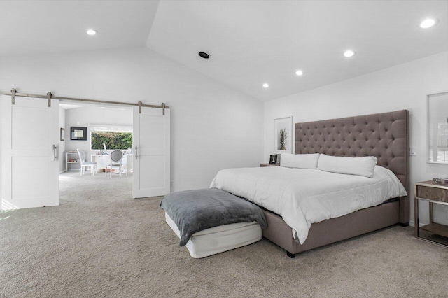 bedroom with carpet flooring, a barn door, and vaulted ceiling