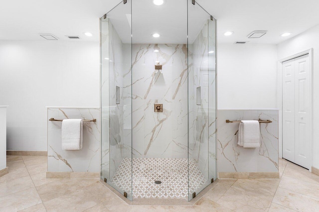 bathroom with tile walls and a shower with shower door