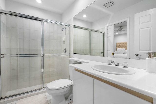 bathroom with ceiling fan, tile patterned flooring, toilet, a shower with door, and vanity