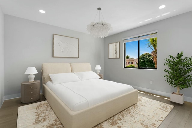 bedroom featuring dark hardwood / wood-style flooring and an inviting chandelier