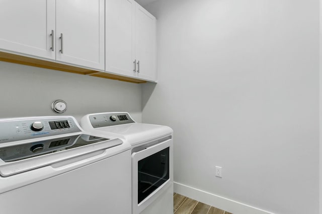 washroom with washer and clothes dryer, cabinets, and light wood-type flooring