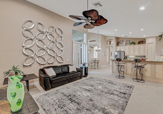 tiled living room featuring ceiling fan with notable chandelier and lofted ceiling