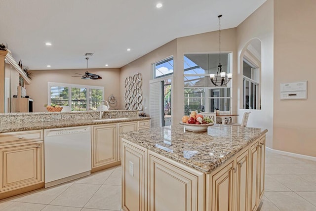 kitchen with cream cabinets, dishwasher, pendant lighting, and vaulted ceiling