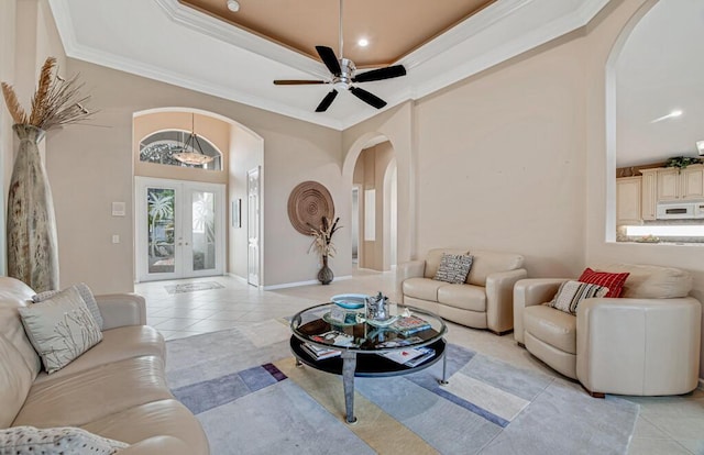 tiled living room with french doors, ceiling fan, and ornamental molding