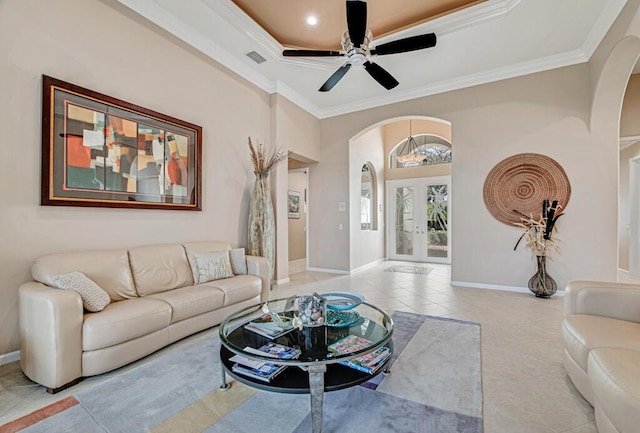 tiled living room with ceiling fan and crown molding