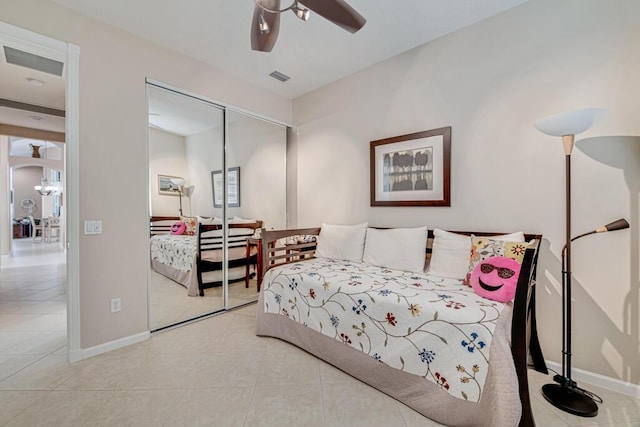 bedroom with ceiling fan, light tile patterned flooring, and a closet