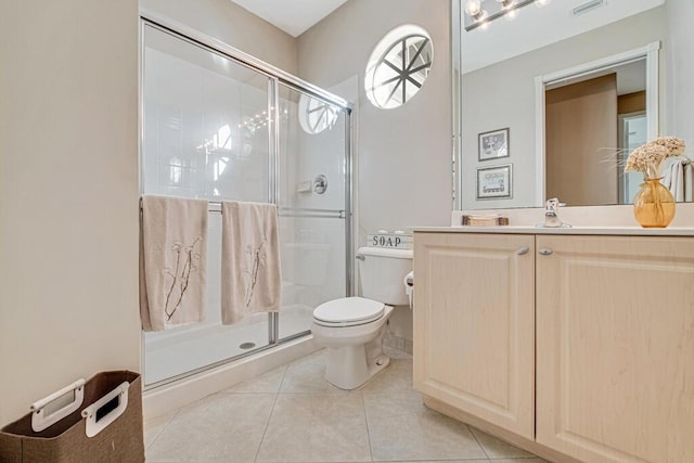 bathroom with tile patterned flooring, toilet, and a shower with shower door