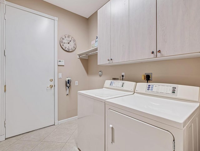 laundry area with cabinets, independent washer and dryer, and light tile patterned flooring