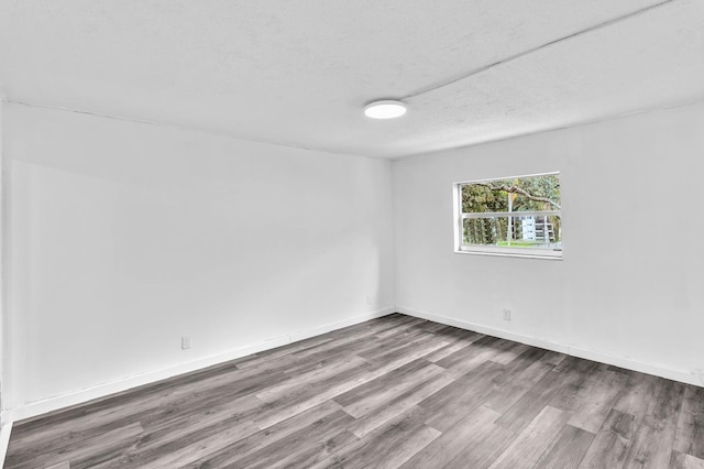 spare room with hardwood / wood-style floors and a textured ceiling