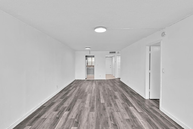 unfurnished living room featuring dark hardwood / wood-style flooring and a textured ceiling