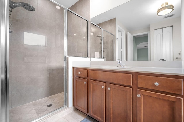 full bath with vanity, visible vents, a stall shower, and tile patterned flooring