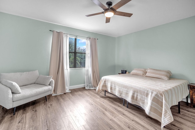 bedroom featuring ceiling fan, baseboards, and wood finished floors