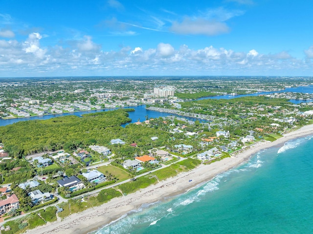 birds eye view of property with a water view and a beach view